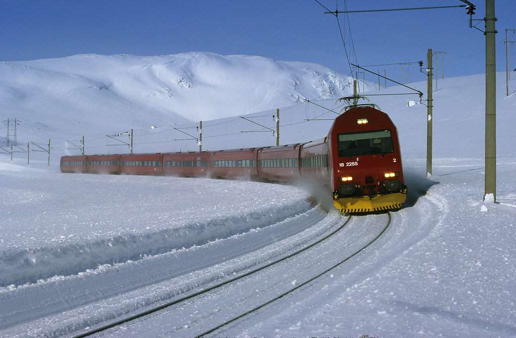 Flåm Railway train in winter conditions on the mountain section. Snow at Myrdal, green valley by Flåm.