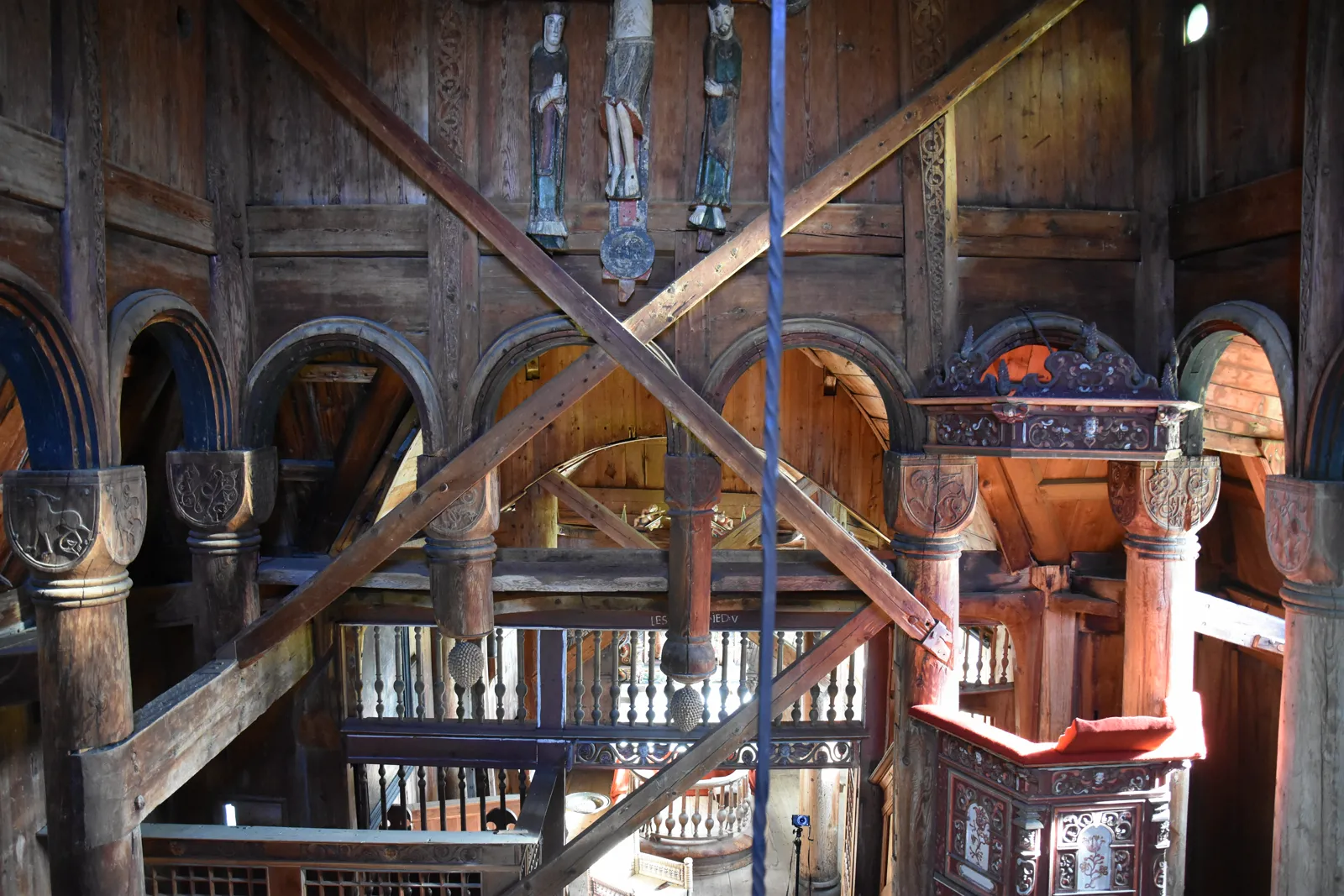 The nave of Urnes Stave Church with carved capitals, scissor braces and the medieval calvary group