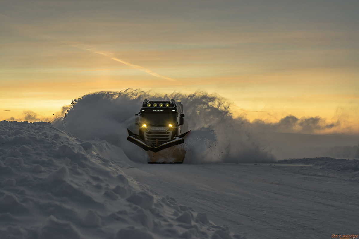 Winter convoy vehicles following a snowplough on the E69 road to North Cape through deep snow